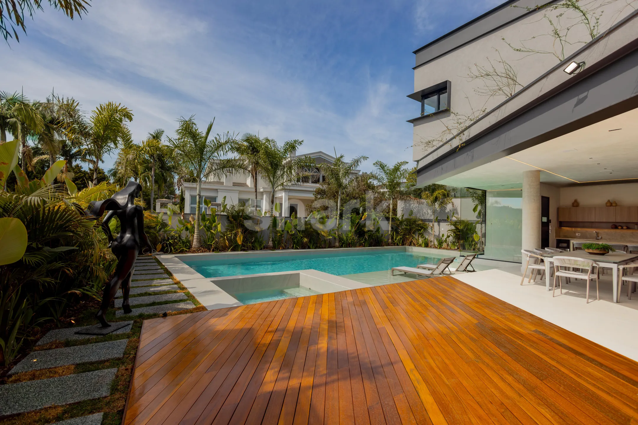 Deck de madeira e piscina entre as palmeiras