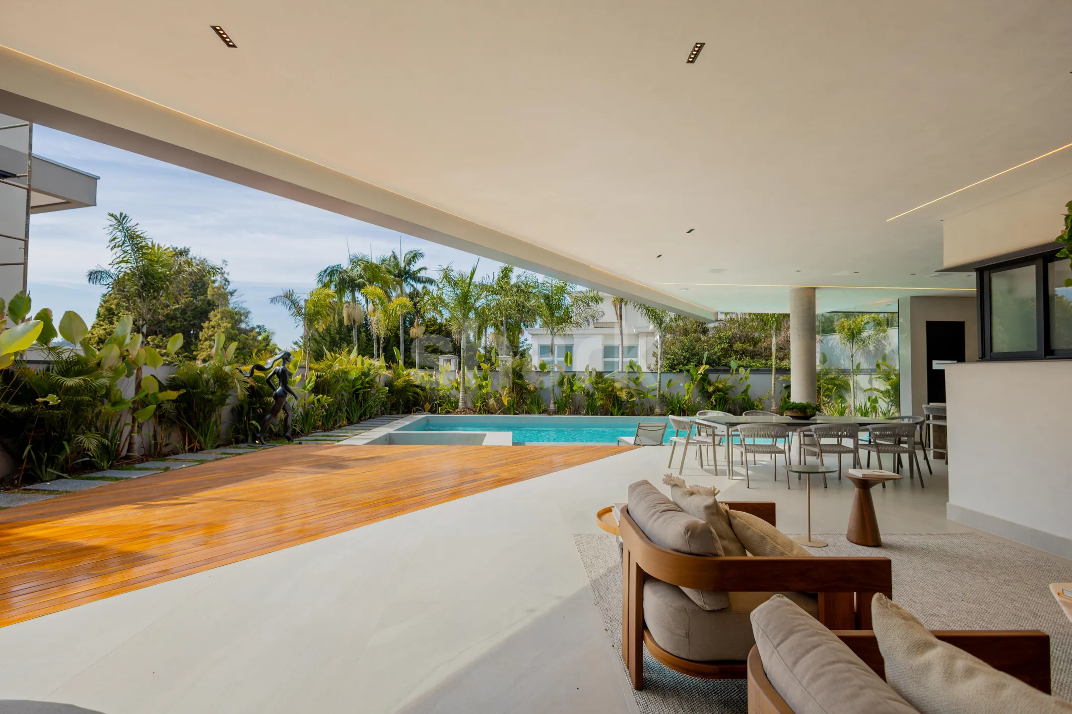 Varanda coberta com lounge, deck de madeira e piscina