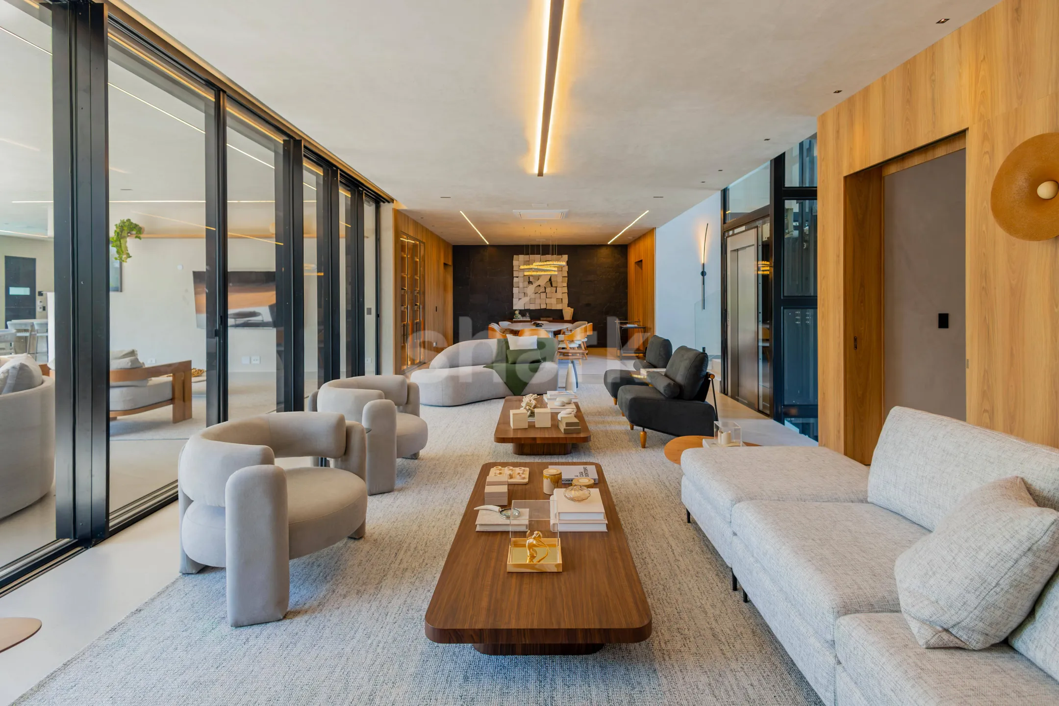Sala de estar ampla com sofás claros e mesa de centro de madeira