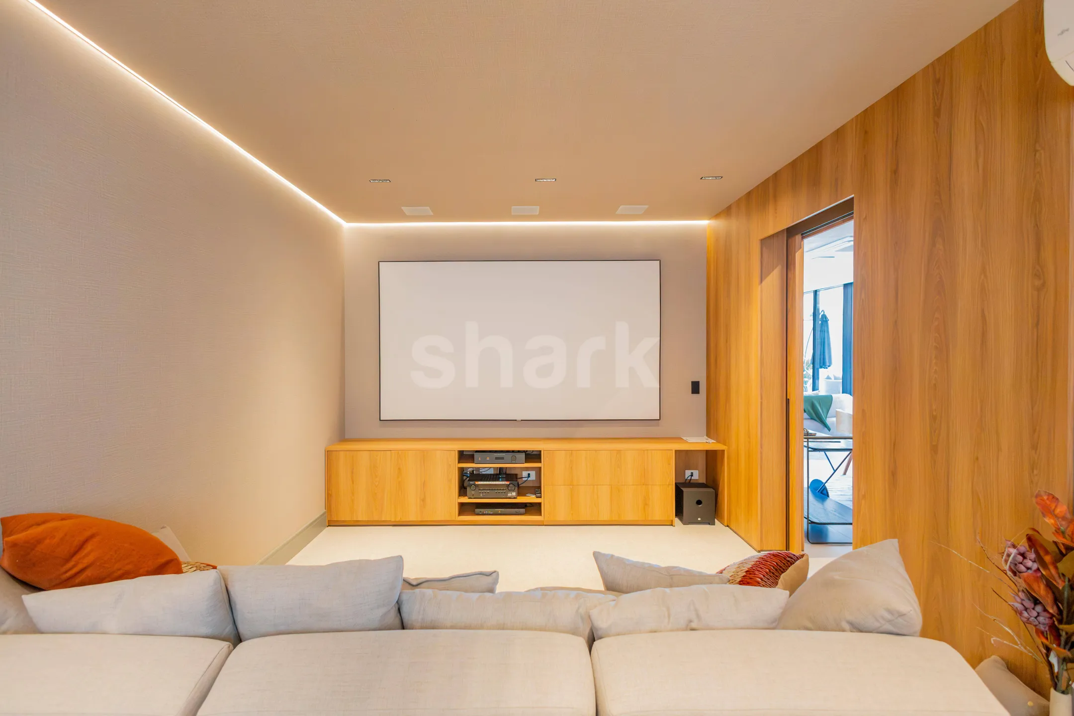 Home theater com tela de projeção e sofá de canto